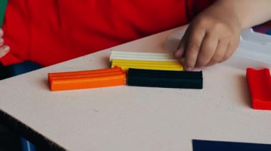 Video, renkli plastikten heykel yapan küçük bir çocuğun elleri. Yakın plan..