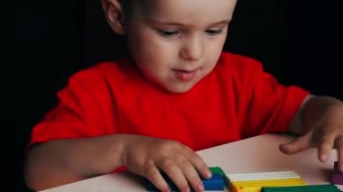 Küçük bir çocuğun renkli plastiklerden heykeller yaptığı bir video.