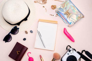 Yaz seyahati aksesuarları. Yetişkin oyuncakları, kamera, şapka, gözlük ve arka planda üst görünüm. Metnin için boşluk