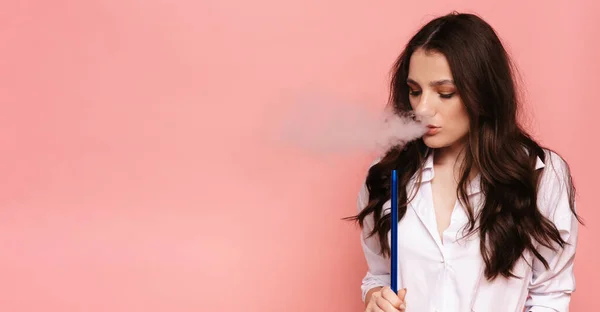 Joven, hermosa chica fuma una cachimba, shisha. Produce humo de su boca. El placer de fumar. Lugar para su texto. — Foto de Stock