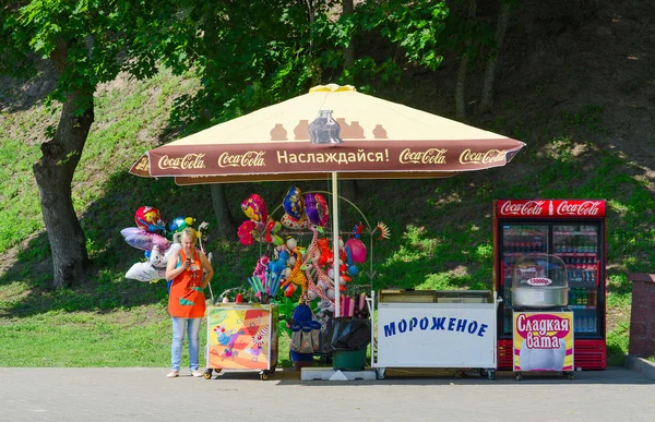 Γυναίκα-πωλητή στο πάρκο στο γκισέ με παγωτό, μπαλόνια — Φωτογραφία Αρχείου
