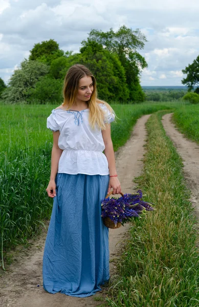 Güzel genç kadın ile kır çiçekleri sepeti 