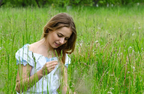 Young beautiful woman sitting in meadow grass — Stock Photo, Image