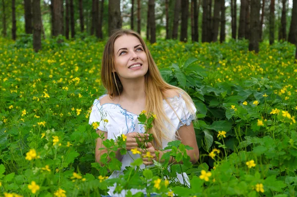 Porträtt av vacker ung kvinna i skogen bland blommor — Stockfoto