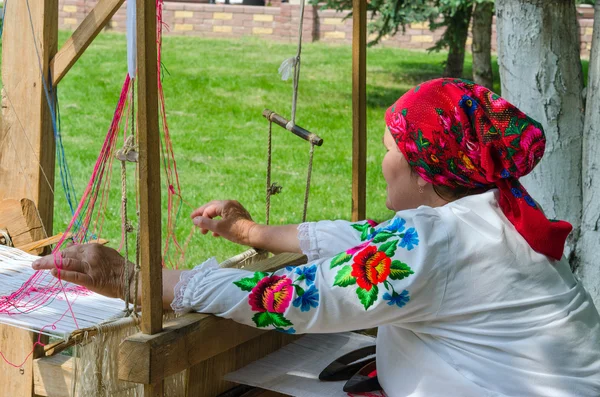 Belorussian craftswoman works at the loom — Stock Photo, Image