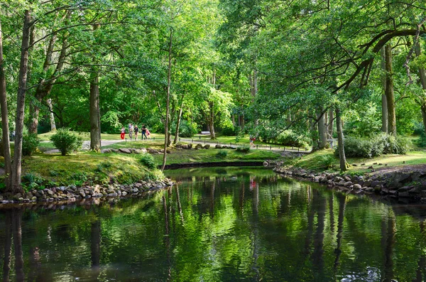 Lithuania, Palanga. People walk in the Botanical park near pond — Zdjęcie stockowe