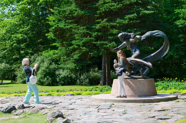 Tourists are photographed at sculpture Egle - Queen of snakes  in the Botanical park in Palanga, Lithuania — Stock fotografie