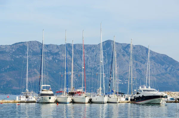 Zeilboten in de buurt van de kust van Budva op de achtergrond van bergen — Stockfoto