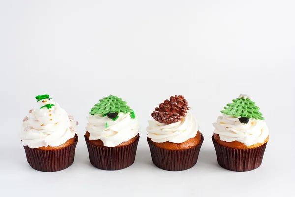 Ingericht Nieuwjaar cupcakes staan in een rij op witte achtergrond — Stockfoto