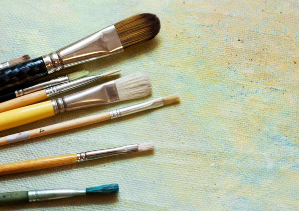 Paint brushes on an oil canvas — Stock Photo, Image