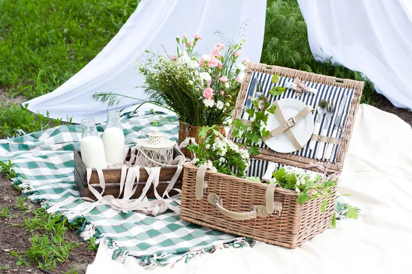 Picnic basket decorated with flowers outside — Stock Photo, Image