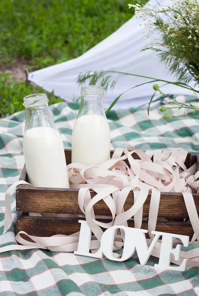 Bir yaz piknik açık havada üzerinde süt şişeleri ile beyaz kelime aşk