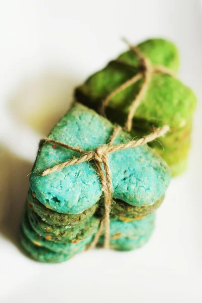 Verde corazón en forma de galletas inclinadas sobre fondo blanco — Foto de Stock