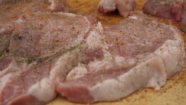 Espolvorear los filetes de cerdo con especias en una tabla. solomillo de cerdo — Vídeos de Stock