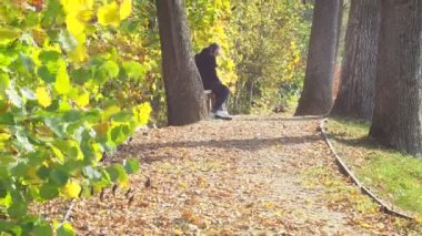 Genç bir kadın bankta otururken kalemle doğayı çizer. ressam çalışıyor