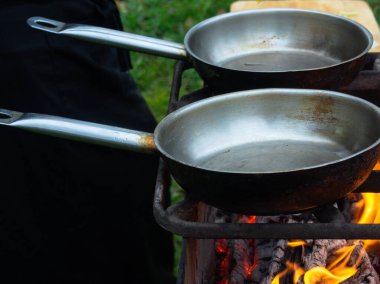 Parlak bir ateşte kızartma tavası. Ateşin üstünde yemek pişirmek. Ateş yanıyor.