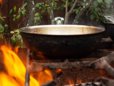 Parlak bir ateşte kızartma tavası. Ateşin üstünde yemek pişirmek. Ateş yanıyor.