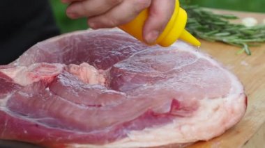 Ete baharat ve tuz serpiyorsun. Kemiğin üzerinde jambon pişirmek.