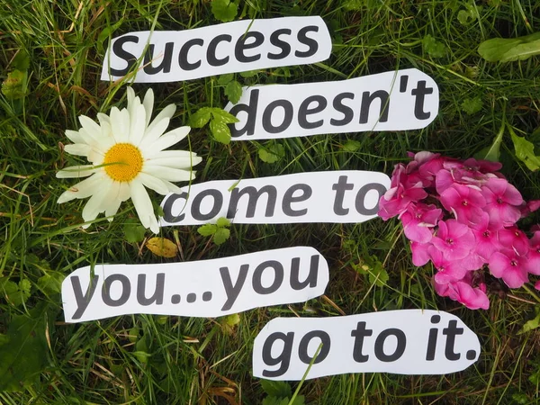 Başarı sana gelmezse ona gidersin. Çimlerin üzerinde kağıt harflerden yapılmış harfler var.