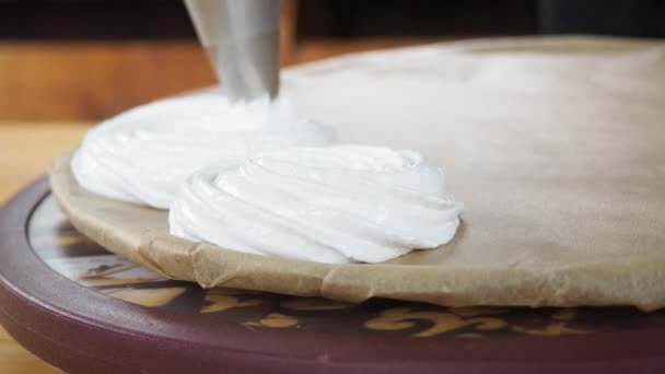 Voorbereiding van meringue decoraties. banketbakker perst meringue crème op een draaibank — Stockvideo