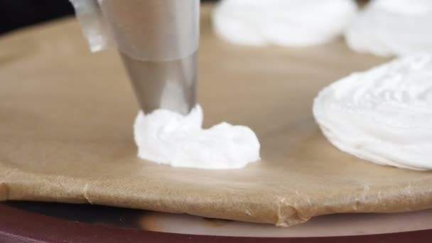 Voorbereiding van meringue decoraties. banketbakker perst meringue crème op een draaibank — Stockvideo