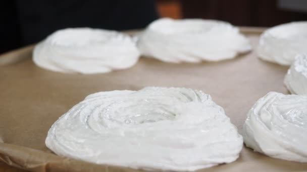 Preparação de decorações de merengue. chef de pastelaria espreme creme de merengue em uma placa de fiação — Vídeo de Stock