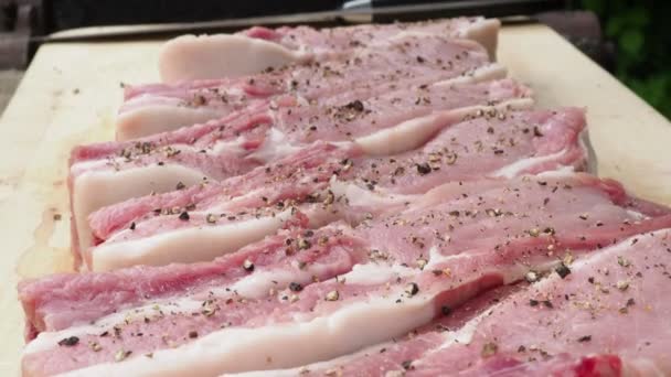Чоловічі рукавички посипати спеціями і сіллю на стейках зі свинини — стокове відео