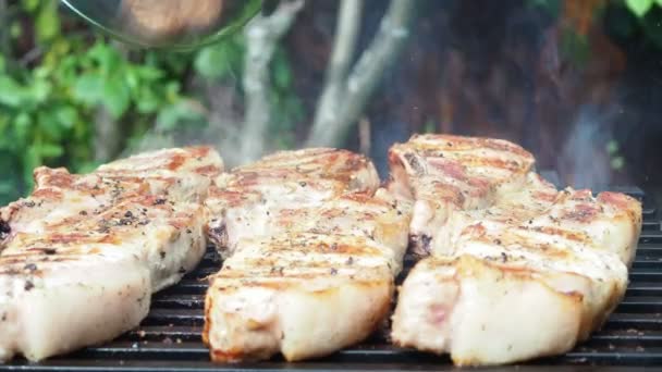 Kuchař nalije na gril alkohol a zapálí ho. flambe.cooking vepřové steaky v ohni — Stock video