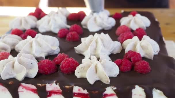 Decorazione torta spremendo la crema dalla borsa. torta al cioccolato con rose crema — Video Stock