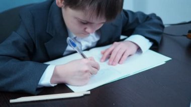 Ceketli bir çocuk not defterine grafik çiziyor. Genç finansör