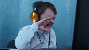 Gömlekli ve kulaklıklı bir çocuk gözlerini kırpıyor ve sosyal ağda bir mesaj yazıyor.