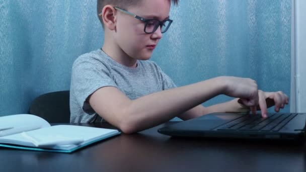 Pojken med glasögon får inte uppgiften. förtret i ansiktet. Han knuffar undan laptopen och tar av sig glasögonen. — Stockvideo