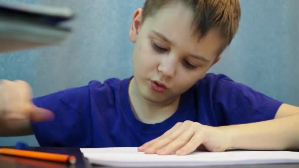 The boy draws a picture with a pencil and wipes it with a wipe — Stock Video