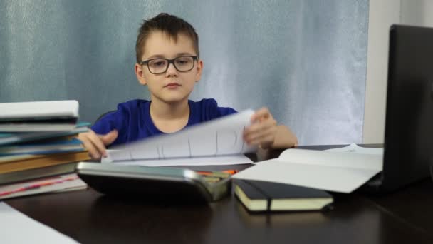 Уставший мальчик, сидящий за столом показывает знак, говорящий о помощи. Учиться дома тяжело. эмоции — стоковое видео