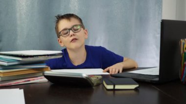 Çocuk masada otururken uyuyakalıyor. Ödev yapamayacak kadar tembel.