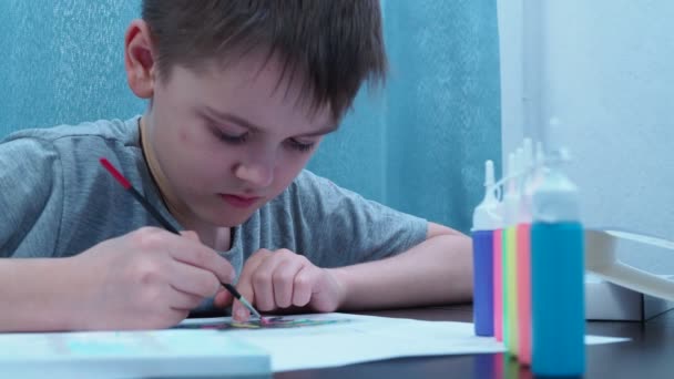 10-летний мальчик рисует кисточкой. Школа искусств. образовательная деятельность с ребенком — стоковое видео