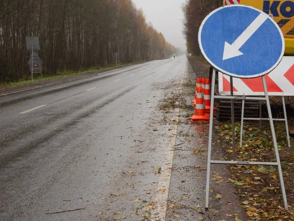 Sağdaki servis yolu tabelası. Yolda geçici trafik işaretleri var. Yolların onarımı