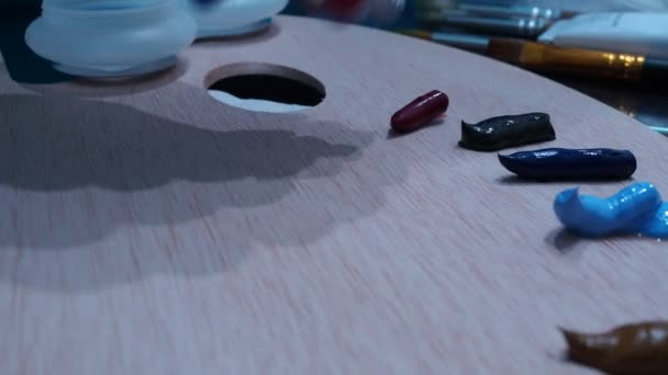 Dívčí ruka vymačká olejomalby na dřevěnou paletu pro kreslení — Stock video