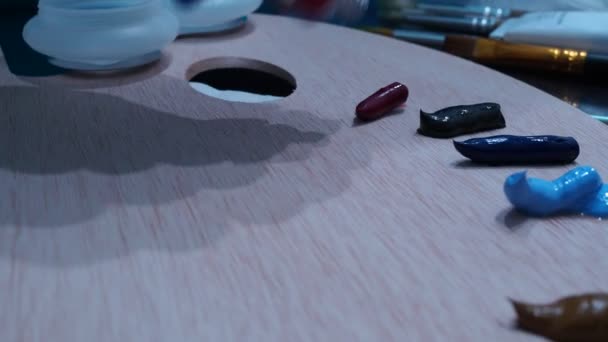 La mano de las muchachas exprime las pinturas al óleo sobre la paleta de madera para el dibujo — Vídeos de Stock