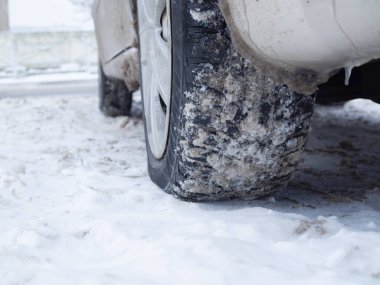 Kış lastikleri üzerinde araba karla kaplı bir yolda. Lastiğe bas..