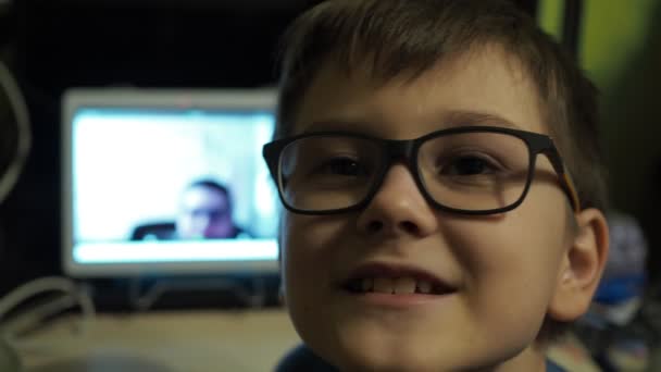 Un joven profesor enseña una lección sobre el zoom. clases en casa.un chico con gafas habla a la cámara — Vídeos de Stock