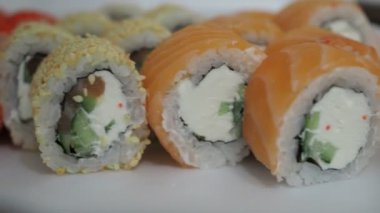 Kırmızı balıklı suşi, susam tohumu ve peynir. Japon mutfağı.