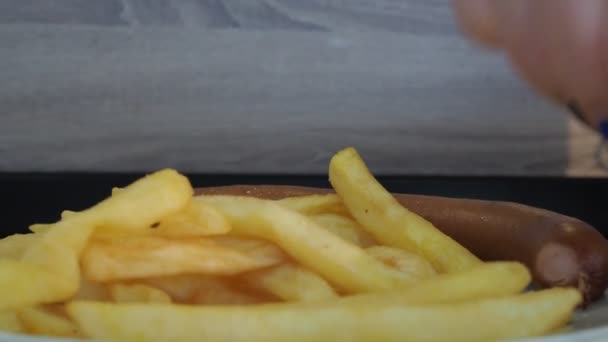 Sepiring kentang goreng dan sosis di atas meja. cepat saji — Stok Video