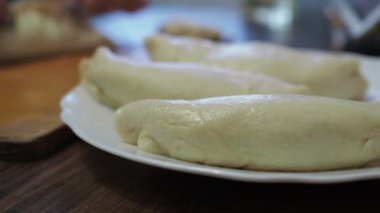 Kadınların elleri mantar hamuruna sarılır. Mutfakta turta pişirmek. Arka planda turta pişirmek.