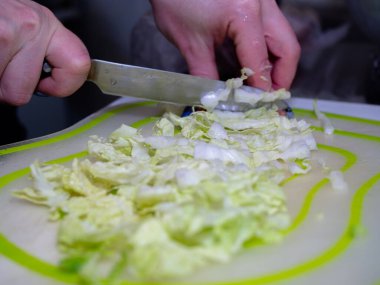 Kadınların elleri kesme tahtasıyla lahana kesiyor..