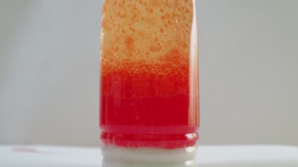 Kemisk erfarenhet. i en flaska olja, en lösning av kemikalier med färgämnen kokar. vackra röda bubblor. vit bakgrund — Stockvideo