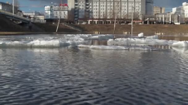 雪が融けた後の川の洪水。水面に波紋が広がっています。春の太陽の下で融ける雪の氷 — ストック動画