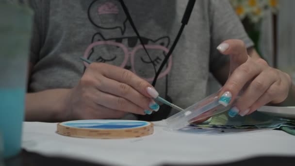 Une femme mélange des peintures à l'huile avec un pinceau et peint sur un arbre. gros plan — Video