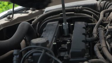 Bir adam tozlu bir araba motoruna buji takıyor. Araba tamiri. planlanmış bakım