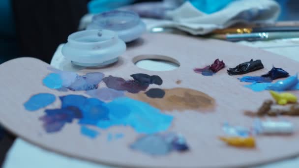 Dívka míchá malbu štětcem z palety. Paleta detailů. boční pohled — Stock video